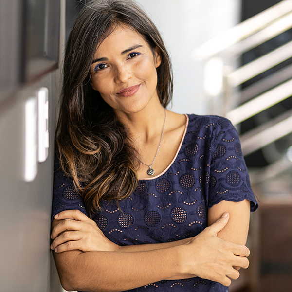 Mulher de pele clara, blusa azul escuro e cabelos longos lisos